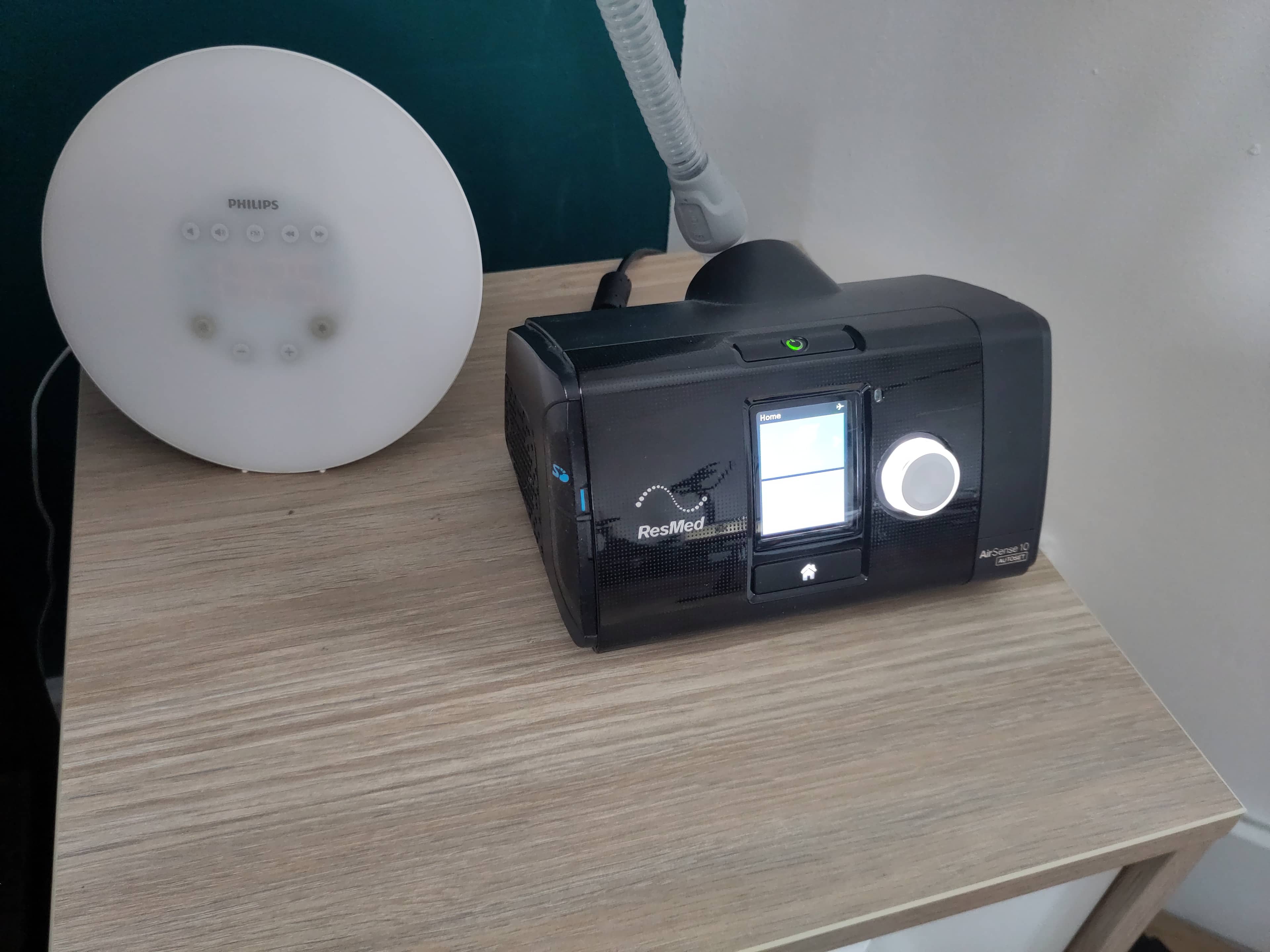CPAP device set up on a nightstand with bedside sleep equipment.